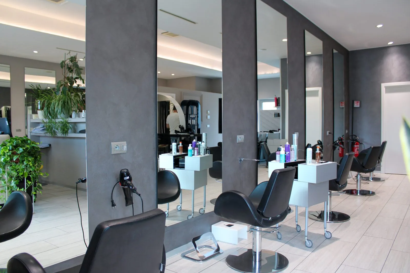 Interno del salone Equipe Oreal Parrucchieri con specchi e postazioni